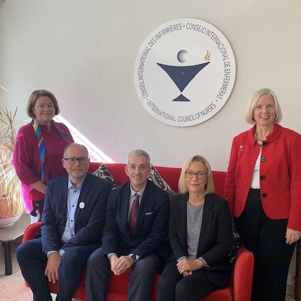 The NPC Research Group with a host from the International Council of Nurses seated on a red sofa beneath the organisation's plaque